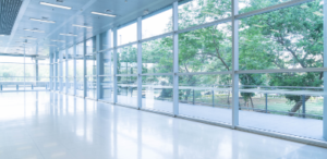 blurred-abstract-background-interior-view-looking-out-toward-empty-office-lobby-entrance-doors-glass-curtain-wall-with-frame